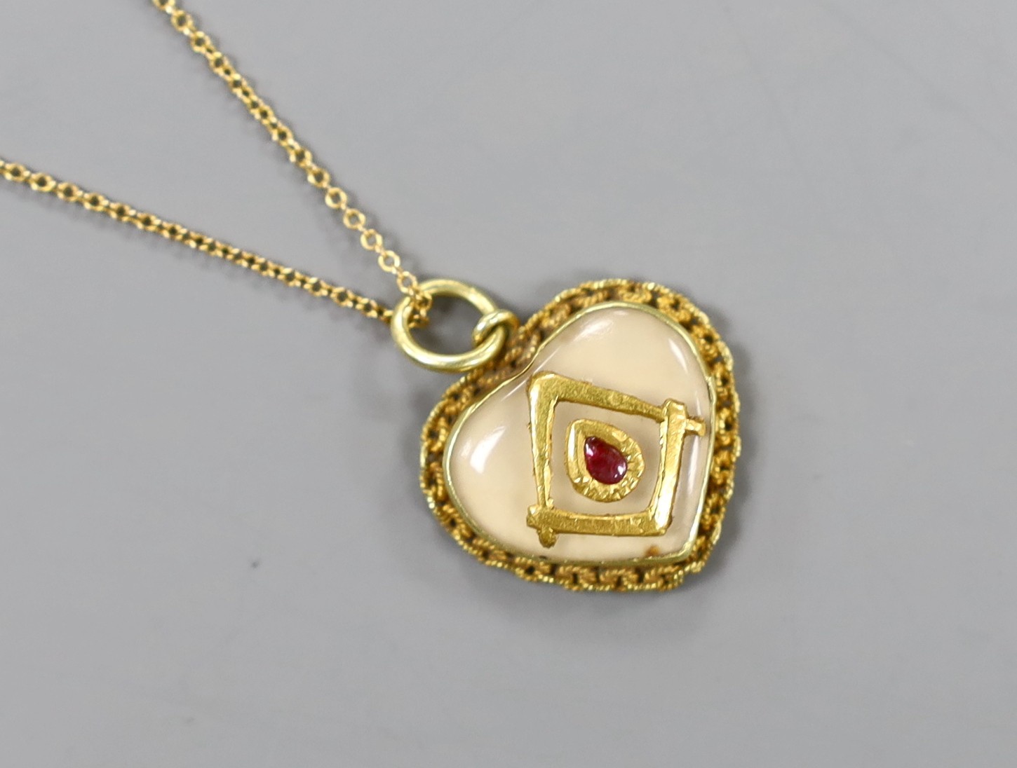 A yellow metal and cabochon gem set heart shaped masonic pendant, 16mm, on a 9ct chain, gross 4 grams.